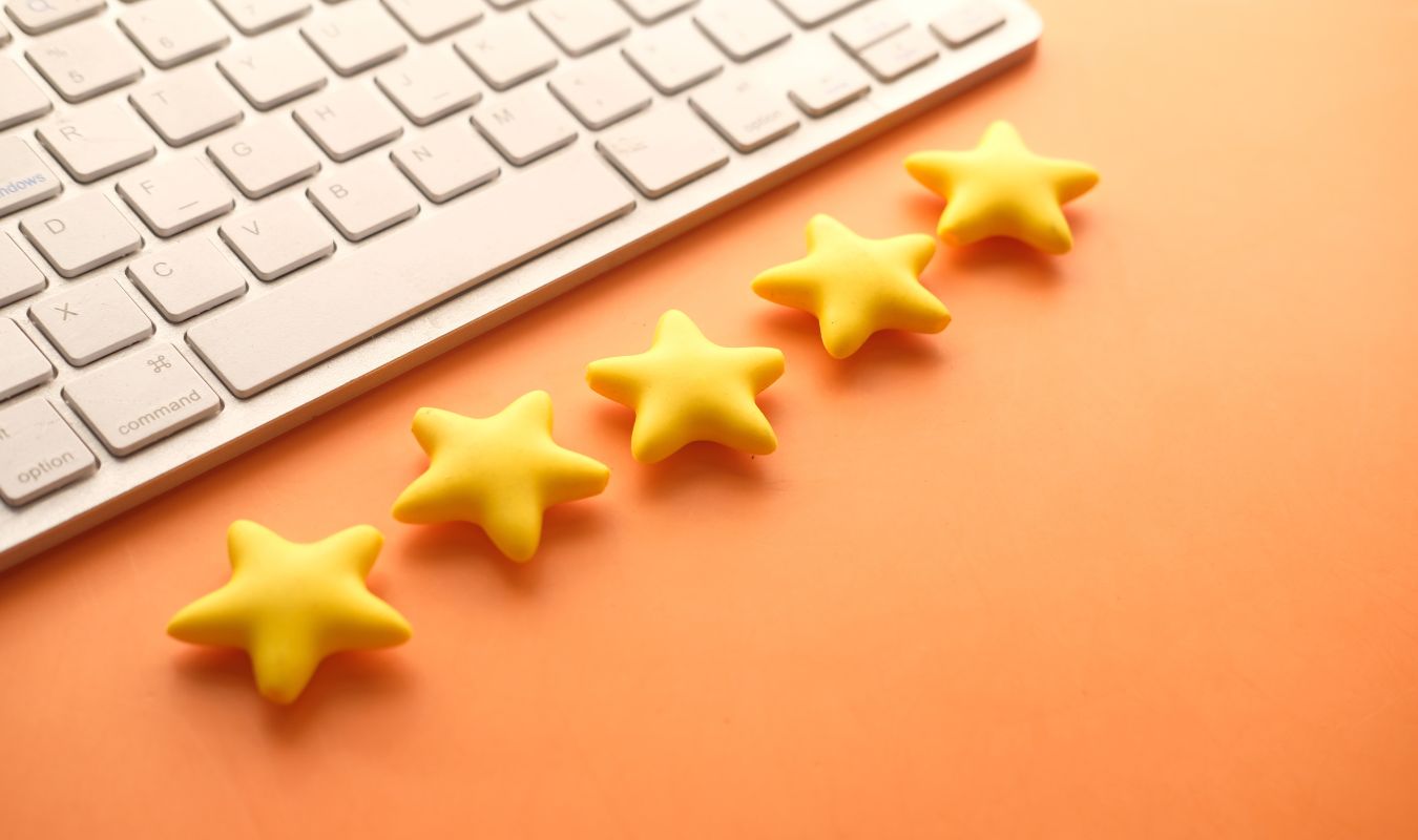 5 étoiles représentées devant un ordinateur, synonymes de la qualité du logiciel de comptabilité Indy